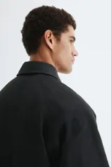 Campera de sarga levemente acolchada con cuello inglés, cierre frontal y solapa con botones. Presenta mangas raglán, bolsillos insertados delanteros, un bolsillo interior y cordón ajustable en el bajo.