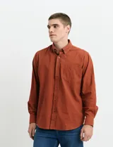 Camisa de franela lisa con cuello button-down, manga larga, botones al tono y bolsillo frontal en el pecho.