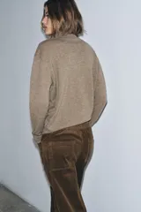 Jersey de cuello alto confeccionado en lana 100%, de manga larga y diseño clásico con acabado de tacto suave.