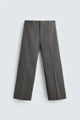 Pantalón de vestir con corte flare y ajuste relajado, confeccionado en tejido con viscosa y patrón de espiga. Cuenta con bolsillos frontales, bolsillos traseros de vivo y cierre frontal con cremallera y botón.