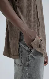 Sudadera sin mangas (tipo chaleco) de tejido liviano acanalado, color marrón chocolate, con calce amplio y recortes superpuestos que generan textura.