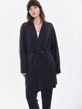Bata de micro polar color negro, de manga larga y corte holgado, con lazo ajustable en la cintura.