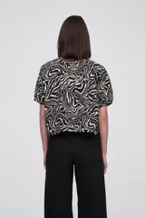 Blusa de algodón con estampado animal print tipo cebra, cuello redondo y mangas cortas abullonadas con diseño de globo.