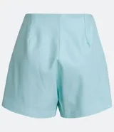 Short pollera de material sintético color celeste, con diseño cruzado en la parte delantera y cierre lateral con cremallera.
