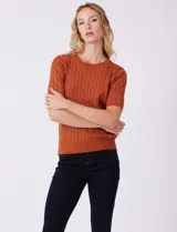 Buzo tejido marca Tahari, color naranja, con cuello a la base, manga corta y diseño de ochos.