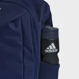 Mochila deportiva Adidas de color azul marino, con tres franjas blancas verticales en el panel frontal y el logo de la marca en la parte inferior. Posee bolsillos laterales de malla y un compartimento inferior con cierre.