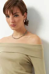 Remera color beige, strapless y de manga larga, confeccionada en algodón.