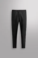 Pantalón de entrenamiento slim fit Zara Athleticz color negro, confeccionado en tejido técnico ligero y elástico con estructura combinada a contraste. Cuenta con cintura elástica ajustable con cordón, bolsillos frontales y trasero con cierre de cremallera, y bajo ajustable con cremallera en los laterales.