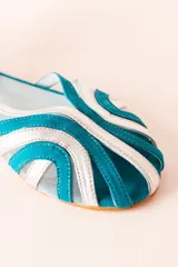 Sandalias tipo cangrejeras plateadas y celestes, con rejilla en la punta y tira al tobillo. Fabricadas en España.