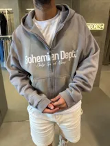 Campera con capucha y cierre frontal, de corte boxy y diseño holgado. Presenta estampado frontal con el logo de la marca Bohemian Dept. y la frase Only Good News.