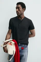 Camiseta blanca de manga corta con cuello redondo y tapeta de botones frontal (cuello panadero o henley).