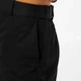 Pantalón pitillo negro con dos bolsillos laterales y dos bolsillos traseros.