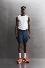 Short de entrenamiento deportivo con diseño 2 en 1, que incluye una capa exterior de tejido técnico ligero y una malla interior ajustada. Cuenta con cintura elástica con cordón de ajuste, bolsillos laterales con cierre y aberturas en el bajo.