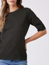 Buzo de tejido fino en color azul marino, con cuello redondo y mangas cortas con puños acanalados.