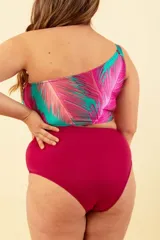 Malla enteriza de lycra con estampado de hojas de palmera en tonos turquesa y fucsia. Diseño asimétrico con un solo hombro y abertura lateral.