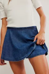 Falda pantalón de denim azul, de tiro medio y línea A, con short interno y bolsillos laterales.