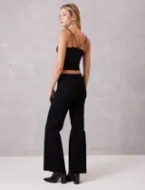 Jean wide leg marca Elan, color negro, de tiro alto con pierna ancha desde la cadera hasta el ruedo. Incluye pretina con pasadores, botón y cierre, y bolsillos funcionales en la parte delantera y trasera. La terminación del ruedo es deshilachada.