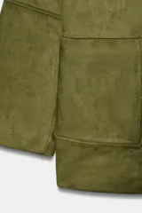 Abrigo de ante sintético color verde militar, con cuello solapa, manga larga, bolsillos delanteros de parche y cierre frontal con botones oscuros.