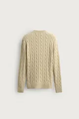 Sweater de punto con diseño de trenzas, color beige, cuello redondo y manga larga con terminaciones en rib.
