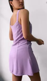 Vestido corto lila con breteles finos y botones frontales.