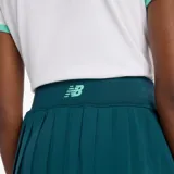 Pollera short deportiva de color verde petróleo, con diseño de cintura alta y detalle de línea vertical en tono verde claro. Cuenta con short interior incorporado y tejido de secado rápido.