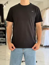 Remera negra de corte clásico y mangas cortas, con pequeño logo impreso en el pecho.