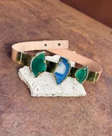 Cinturón de cuero color beige con tres apliques centrales de ágata pulida engarzada en metal dorado. Los apliques son de forma irregular, dos de color verde y uno central de color azul y blanco.