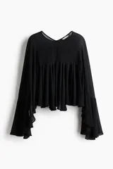 Blusa corta de tejido liviano con diseño oversized, escote redondo y mangas largas acampanadas con volados. Presenta costura fruncida en el pecho que aporta volumen y abertura en V en la espalda.