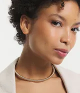 Collar choker dorado de metal con textura de serpiente y diseño de muelles.