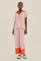 Pantalón tejido color rosa con terminaciones en crochet color naranja, de largo hasta los tobillos, con un fit holgado y cintura elastizada.