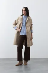 Camisa de rayas verticales con cuello mao, detalle de volados en el escote, bordados florales y recortes con calados. Posee mangas largas abullonadas con puños ajustados y cierre frontal con botones.