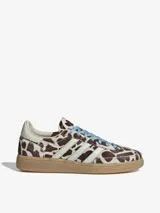Championes Adidas modelo Handball Spezial W, con estampado animal print tipo vaca en tonos marrones y blancos, tiras laterales blancas, cordones celestes y suela de goma translúcida.