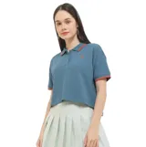 Remera polo Converse de manga corta, color azul, de tejido waffle con detalles en tono rojizo en el cuello y los puños. Presenta un pequeño logo bordado en el pecho.