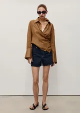 Short de denim azul oscuro, de tiro alto y corte recto, con cinco bolsillos, trabillas y cierre frontal con cremallera y botón.