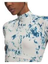 Remera deportiva Under Armour de corte crop y cuello alto, con mangas cortas raglán. Presenta un estampado tipo tie-dye en tonos azul y blanco, con el logo de la marca en el centro del pecho.