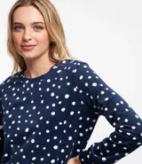 Pijama largo de plush color azul marino con estampado de lunares blancos, compuesto por una blusa de manga larga con cuello redondo y un pantalón con cintura elástica.
