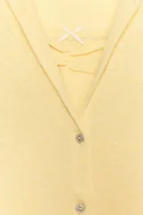 Top de manga corta color beige melange, con escote redondo y diseño cruzado frontal que simula un doble uso con detalle de lazo en el pecho.
