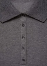 Polo de manga larga confeccionado en tejido de punto fino, con cuello clásico y cierre frontal de botones. Presenta un diseño entallado y acabado acanalado.