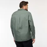 Camisa de corte recto y manga larga, color verde con estampado de pequeños puntos blancos. Presenta cuello clásico y cierre frontal con botones.