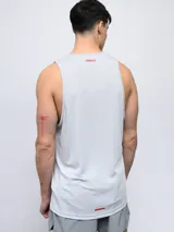 Musculosa deportiva Umbro color gris claro, con cuello redondo y logo Umbro en color rojo en el pecho. Presenta tejido de malla en la espalda para mayor ventilación.