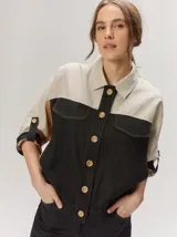 Chaquetas de lino bicolor en tonos blanco y beige, con diseño holgado, cuello alto, cierre frontal de botones, bolsillos con solapa en el pecho y mangas cortas con presilla y botón.