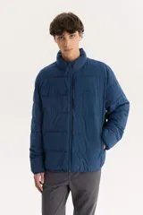 Campera puffer azul marino con cuello alto y cierre frontal con cremallera.