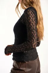 Remera de encaje negro ajustada al cuerpo, de manga larga y diseño transparente.