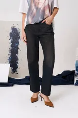 Jean de corte recto y tiro medio, confeccionado en denim de algodón. Presenta cierre frontal con botón metálico, bolsillos laterales y traseros.