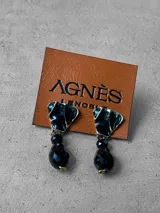 Aros colgantes con diseño de pieza superior triangular en tono verde oscuro con borde metálico y dije inferior de cristal facetado en color negro.