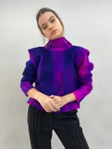 Buzo de lana merino afieltrada con diseño artesanal de efecto degradado en tonos violeta y fucsia. Presenta cuello alto, hombreras marcadas y corte holgado.