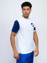 Remera de fútbol blanca con manga derecha azul marino y manga izquierda blanca con una banda azul marino y detalles rojos. Tiene el escudo del Club Nacional de Football en el pecho.