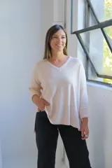 Sweater de punto en color crudo, con escote en V, mangas tres cuartos con puños acanalados y diseño holgado.
