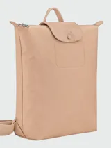 Mochila de diseño minimalista en color beige, confeccionada en material sintético resistente con solapa superior de cuero y cierre de botón a presión. Cuenta con asa superior y correas ajustables.