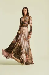 Vestido largo Natalia Antolin modelo Serenna, con escote en V profundo, mangas largas, faja en la cintura y falda larga con vuelo. Presenta un estampado artístico estilo pintura clásica con caballos y paisajes naturales en tonos marrones y beige.